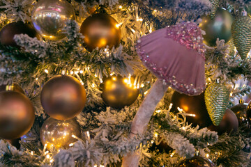 Magic pink mushroom and a lot of Christmas balls on the Christmas tree. New Year mood. Festive Christmas toys. Close-up.