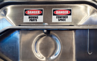 Danger signs on a stainless steel reservoir at a brewery