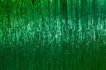 Green Christmas tinsel, festive emerald Christmas background.