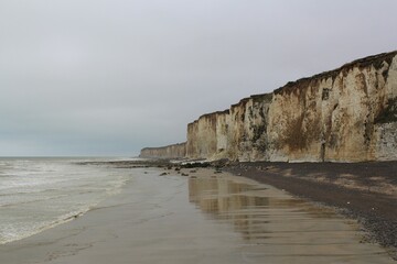 the coast of normandy with big white cliffs along the sea at a stormy day - obrazy, fototapety, plakaty