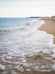 Fototapeta na wymiar bottle in the sand on the beach in summer