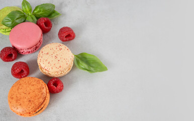 Sweet colorful macarons on a gray background with copy space. French meringue cookies macaron.