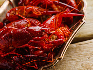 Fresh boiled crayfish on a silver platter on a wooden background. Close-up. Restaurant, hotel, home cooking, banquet, picnic. Recipes for restaurant and home cooking.