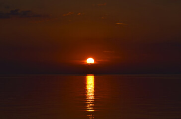 Beautiful sunset on the Atlantic coast. Giant disk of a setting star. Thermonuclear fusion and...