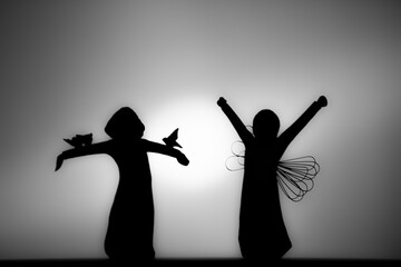 Two angels in silhouette - obrazy, fototapety, plakaty