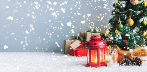 Christmas candles and gift with tags for writing. In the background is a Christmas tree and gifts with lights. New year background.