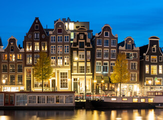 Fototapeta na wymiar Amsterdam in the evening, typical dutch houses and houseboats along the river Amstel