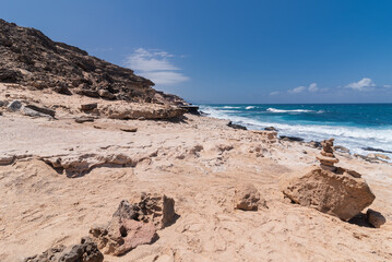 Rocky desert coastline hiking trail with turquoise waters, Canary Islands, Spain