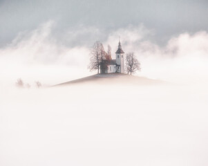 little chapel on a foggy day among  snow