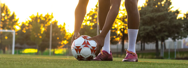 Football player placing the ball on the grass. Low angle of football player putting the ball on the grass in free kick