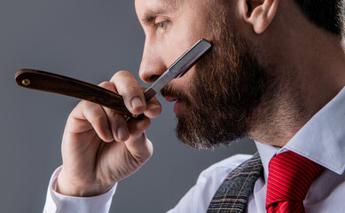 closeup of man barbering in barbershop studio. bearded man at barbershop. unshaven man