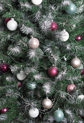 New Year and Christmas background from branches sprinkled with hoarfrost  and elegantly decorated with  Christmas balls, beads, garlands