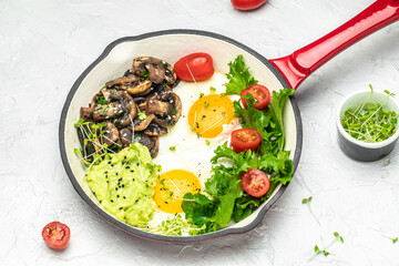 Fried eggs for breakfast with avocado and mushrooms in a pan, Delicious breakfast or snack, Clean eating, dieting, vegan food concept. top view