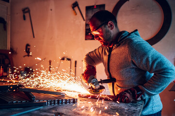 Worker in a factory grinding metal with a grinder