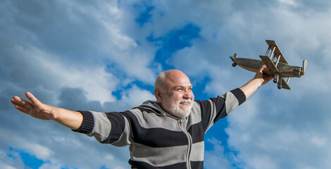 happy retirement. caucasian granddad with toy. retired old man outdoor. senior man at retirement