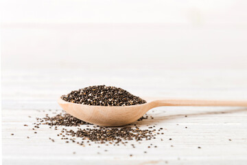 Wooden spoon and chia seeds on colored background, top view. Healthy Salvia hispanica Healthy superfood