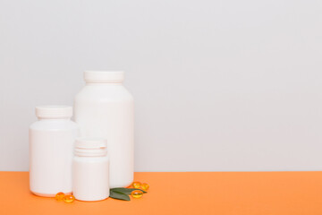 supplement pills with medicine bottle health care and medical top view. Vitamin tablets. Top view mockup bottle for pills and vitamins with green leaves, natural organic bio supplement, copy space