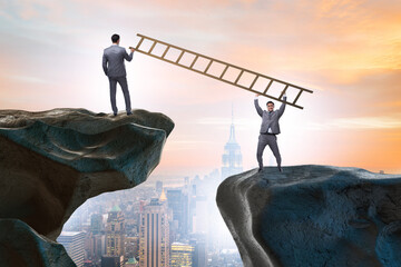 Business people helping to go over chasm