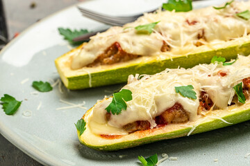 Zucchini stuffed with minced meat and cheese on a dark background. Food recipe background. Close up
