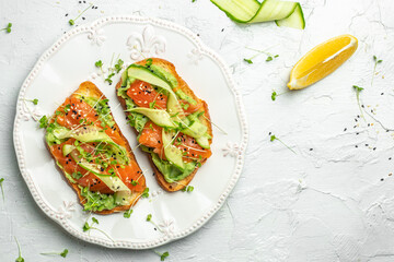 Open sandwiches with salted salmon, guacamole avocado and fresh greens. Delicious breakfast or snack, Clean eating, dieting, vegan food concept. top view.