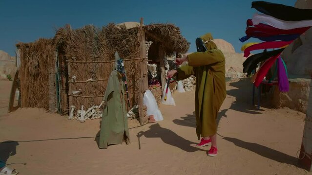 Set stage movie decorations from 1970 man trying on actors props and weapon. Star Wars stage from Sahara in Tunnis.