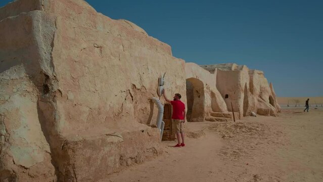 Tourist entering a dwelling from Star Wars film set in Tunisia. Set stage of well known film Star Wars in Sahara, Tunnis.