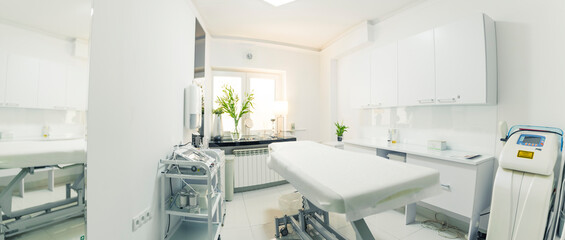 Wide copy space shot presenting clean and bright treatment room at SPA facility and aesthetic medicine salon. Modern ways of relaxation and skin care. High quality photo