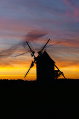 Vibrant and dramatic sky after sunset during twilight with silhouette of traditional windmill, Moulins de Trouguer, Cleden-Cap-Sizun, Brittany, France