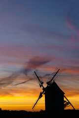 Vibrant and dramatic sky after sunset during twilight with silhouette of traditional windmill, Moulins de Trouguer, Cleden-Cap-Sizun, Brittany, France