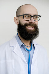 funny face of male charismatic doctor in uniform in white coat with medical instrument stethoscope, young bearded pensive man smiling, medical professional support, health insurance and care