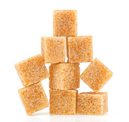 Pile of brown cane sugar cubes isolated on a white background. Pyramid.