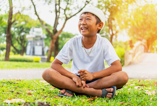 Cute boy in white T-shirt is happily at city park.