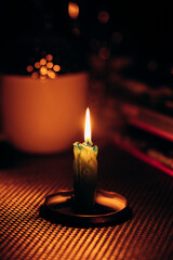 Butt of candle burns out on table. Rolling blackouts in Ukraine. Candlelight dinner during power...
