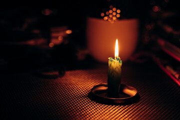 Butt of candle burns out on table. Rolling blackouts in Ukraine. Candlelight dinner during power...