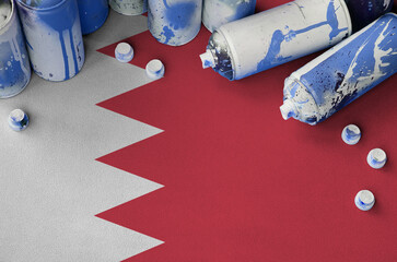 Bahrain flag and few used aerosol spray cans for graffiti painting. Street art culture concept