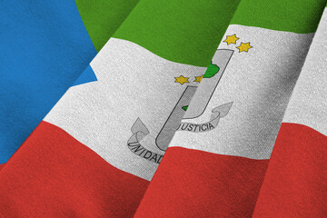 Equatorial Guinea flag with big folds waving close up under the studio light indoors. The official symbols and colors in banner