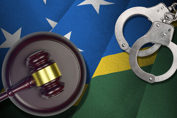 Solomon Islands flag with judge mallet and handcuffs in dark room. Concept of criminal and...