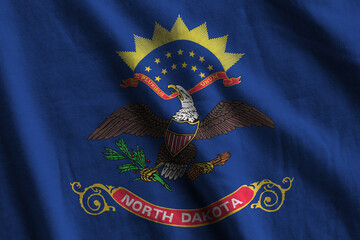North Dakota US state flag with big folds waving close up under the studio light indoors. The...