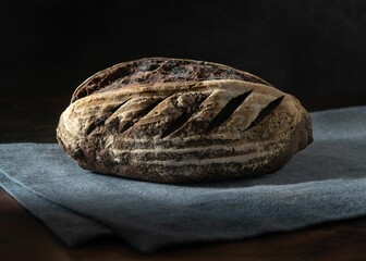 Closeup of sourdough bread on a cloth on a black background