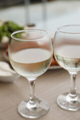Glasses of white wine on wooden table, closeup