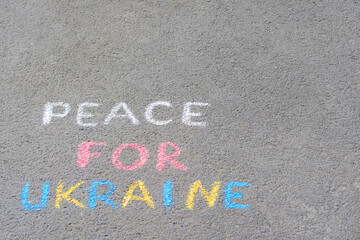 Words Peace For Ukraine written with colorful chalks on asphalt outdoors, space for text