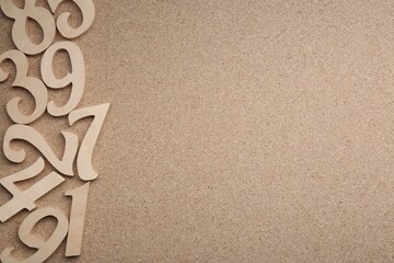 Wooden numbers on fiberboard, flat lay. Space for text