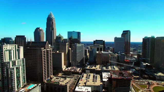 Aerial Shot Of Truist Field By Modern Office Towers In City, Drone Flying Backwards On Sunny Day - Charlotte, North Carolina