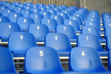 View of empty seats with numbers in the stands. Arena stands are waiting for crowds of fans. Theater, concert hall, audience are ready to start of the performance, lecture or conference.