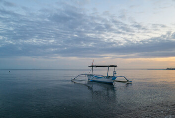 Beautiful morning around Lovina beach with traditional fisherman boats and blue sky as background.