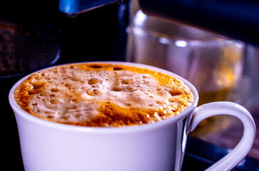 close-up of Coffee foam. espresso crema comes out of the fully automatic coffee machine, Making the coffee machine into a cup. soft focus.