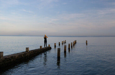 A blonde woman walking and taking pictures around Lovina beach, Bali, Indonesia.