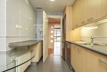 kitchen with beech cabinets, gray countertops and integrated stainless steel appliances