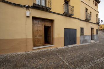 Fototapeta na wymiar Cuarterones wooden gate on a cobbled street on the outskirts of Toledo, Spain