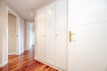Distributor corridor of a house with white carpentry and built-in wardrobes of the same material